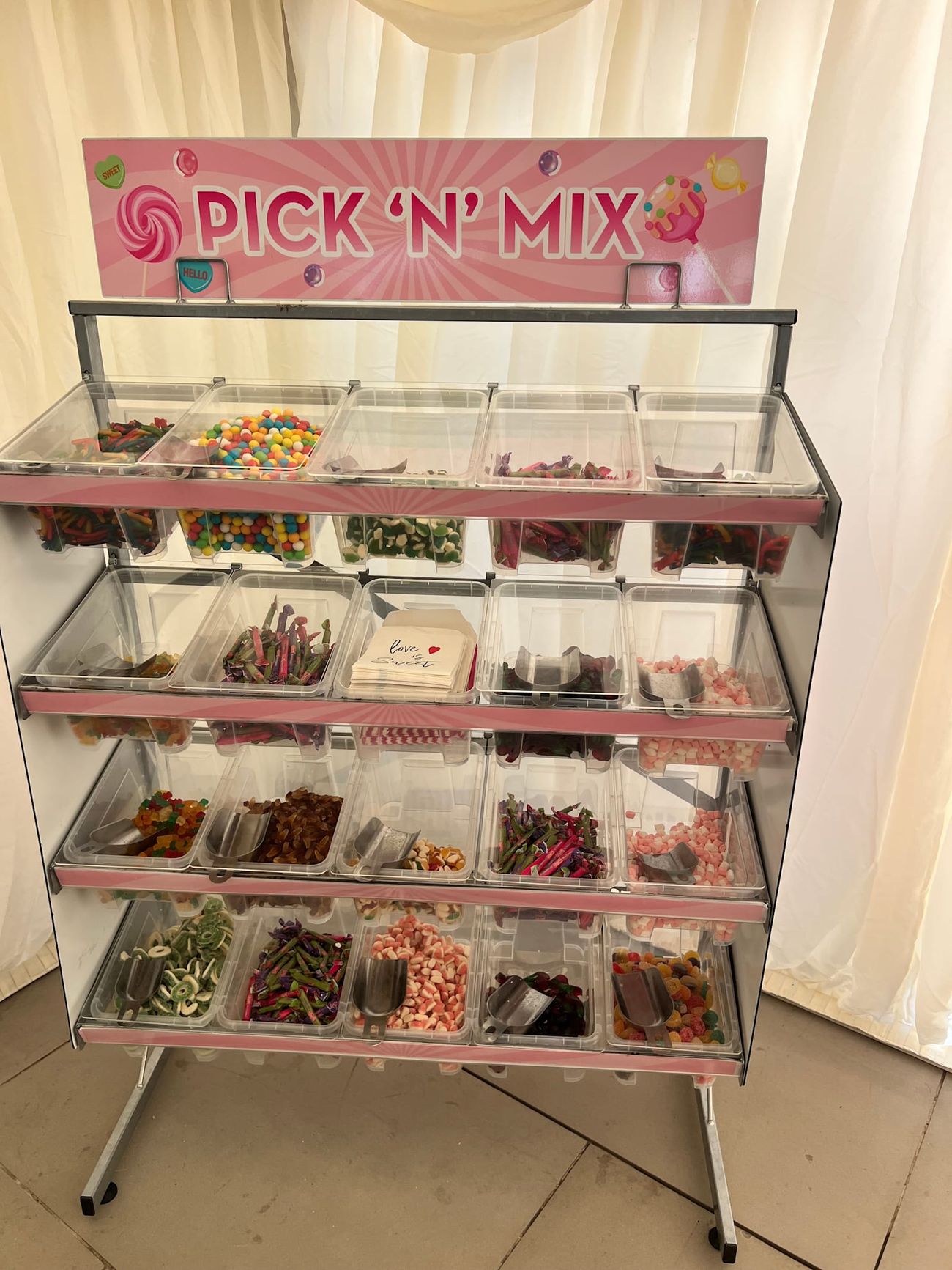 Pick 'n' mix sweet stand at an event, with its multi-tiered clear bins filled with colourful sweets