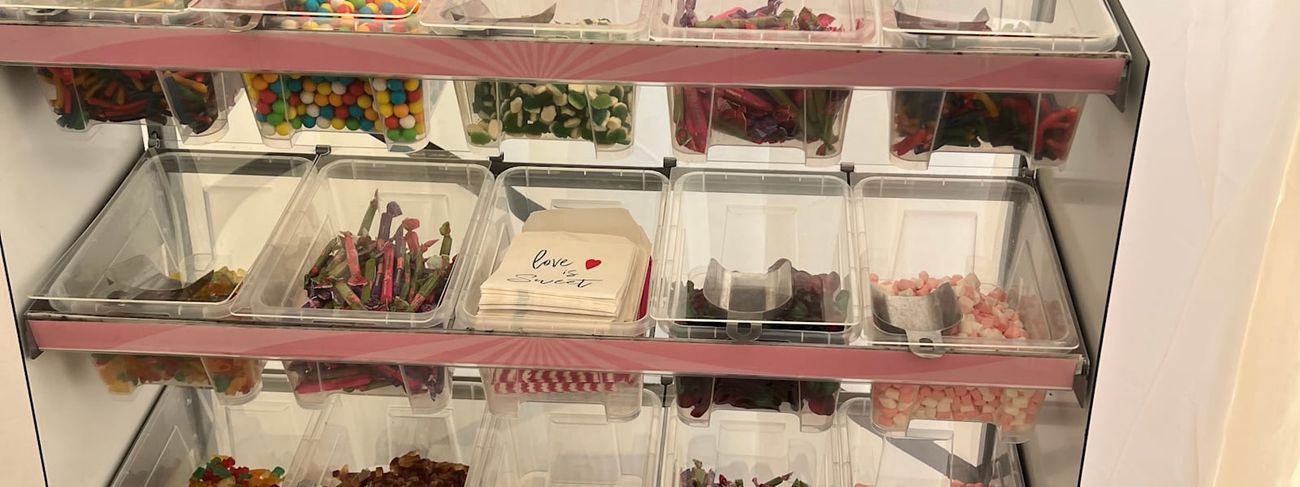 Pick 'n' mix sweet stand at an event, with its multi-tiered clear bins filled with colourful sweets