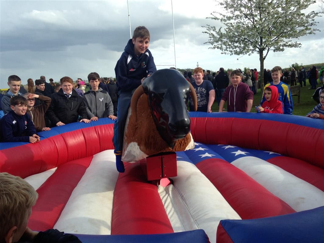 A young rider concentrating on holding on as the bull bucks