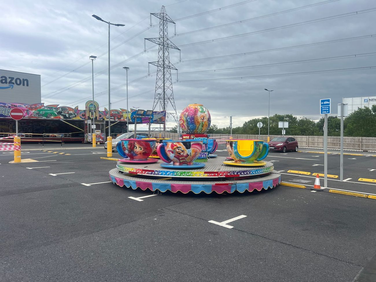 The tea cup ride's cups painted with film characters including Lightning McQueen and Woody, on the pink and blue scalloped base